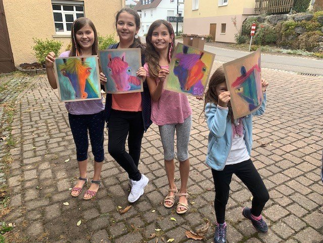 Kinder mit ihren gemalten Kunstwerken